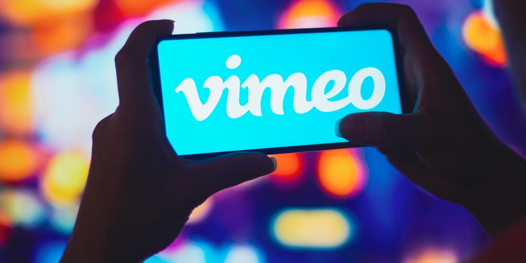man looking at vimeo logo on smartphone